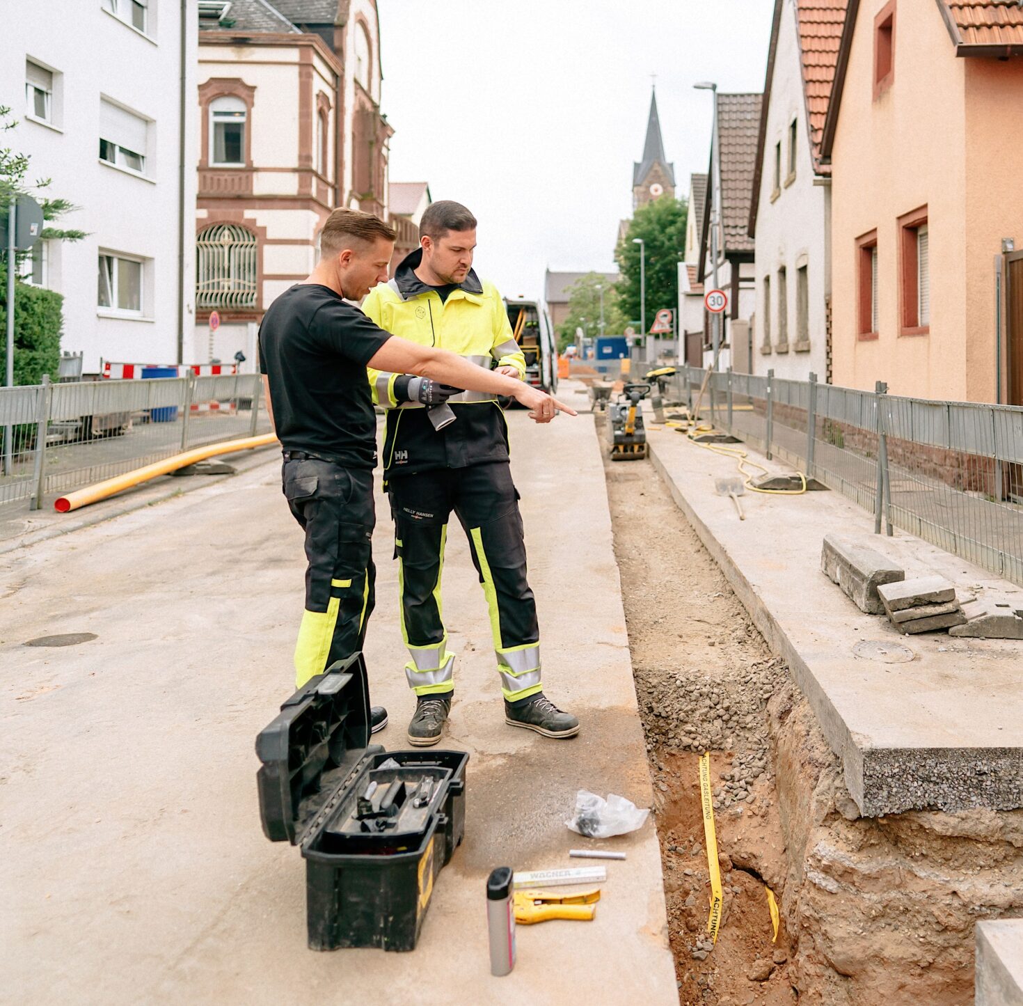 Zwei technische Mitarbeiter vor Rohrgraben