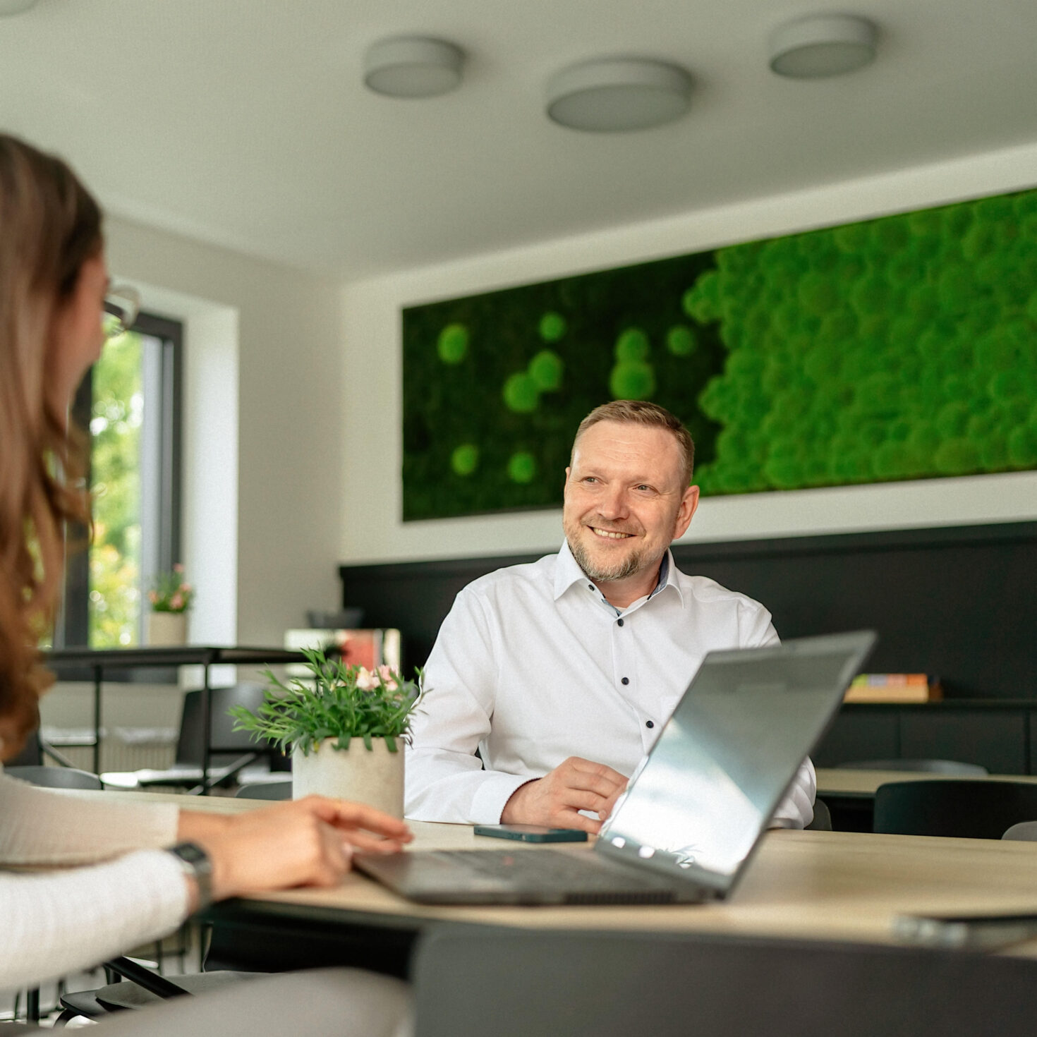 Gespräch Mitarbeiter mit Mitarbeiterin vor Laptop